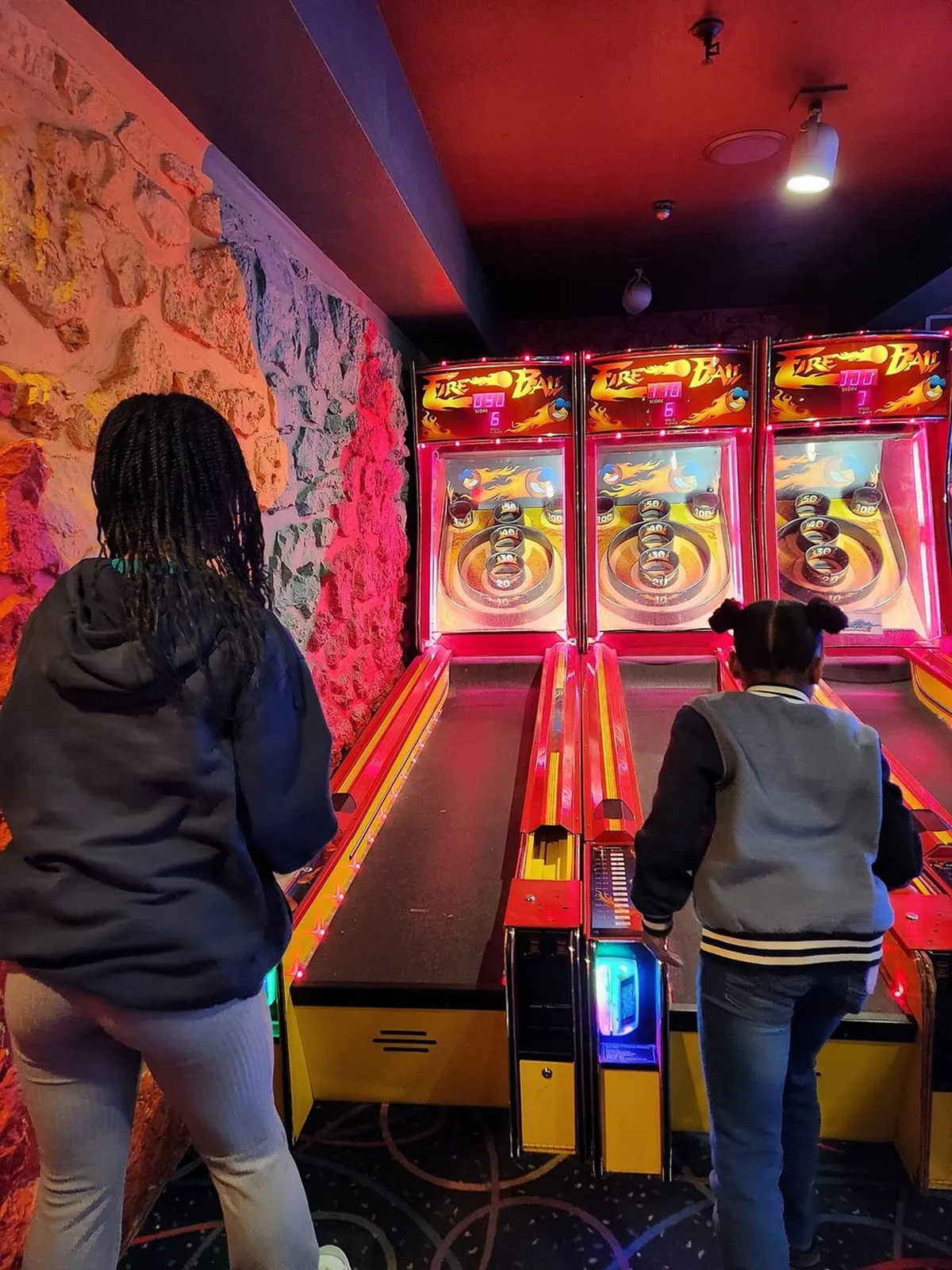 A bustling arcade interior filled with colorful gaming machines and cheerful players, both kids and adults, enjoying friendly competition and celebrating wins. The energetic lighting and smiles capture the excitement of indoor resort activities.