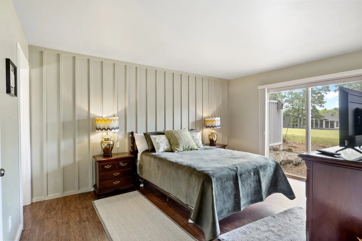 A tranquil bedroom featuring a comfortable bed with plush linens, soft lighting from bedside lamps, and a large window inviting natural light into the space. The gentle décor and cozy atmosphere evoke a sense of calm and relaxation—perfect for unwinding after a day of activities.