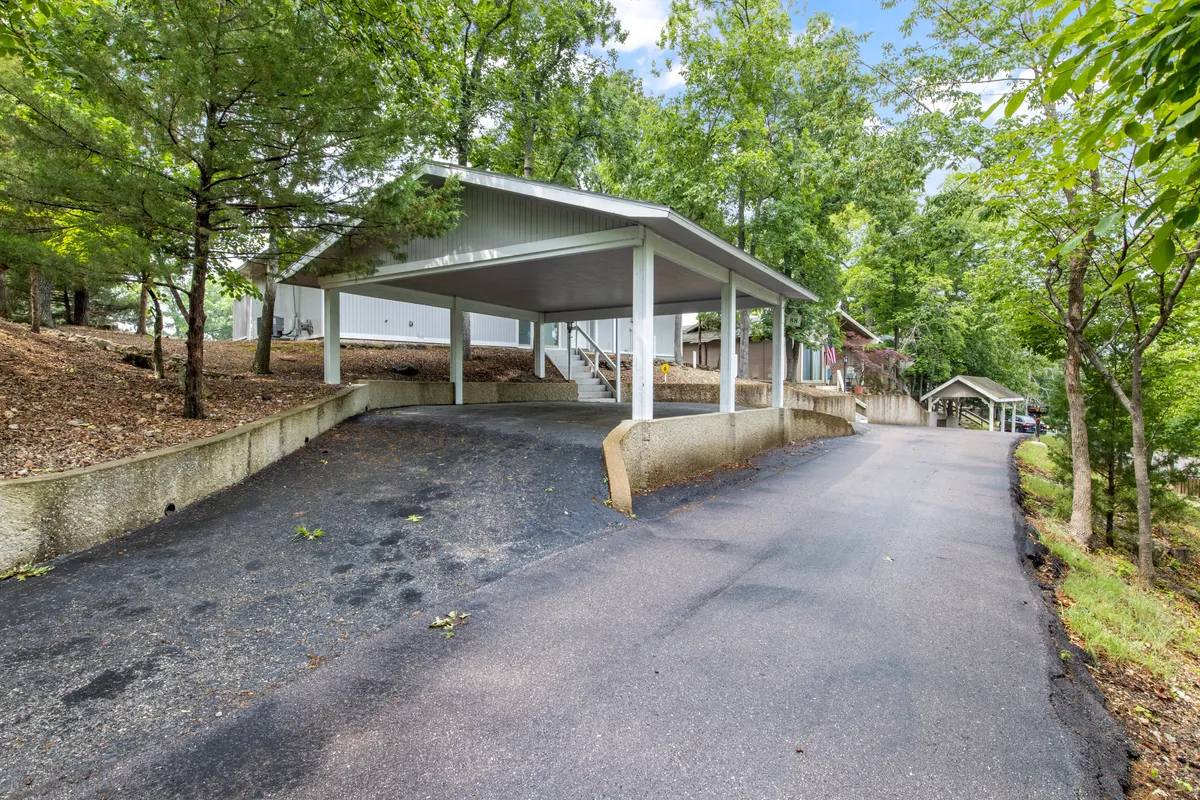 A welcoming view of the property’s covered parking area and surrounding greenery. The driveway and easy-access parking reflect the convenience and accessibility that make family gatherings stress-free.